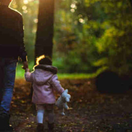 man walking in woods with young daughter